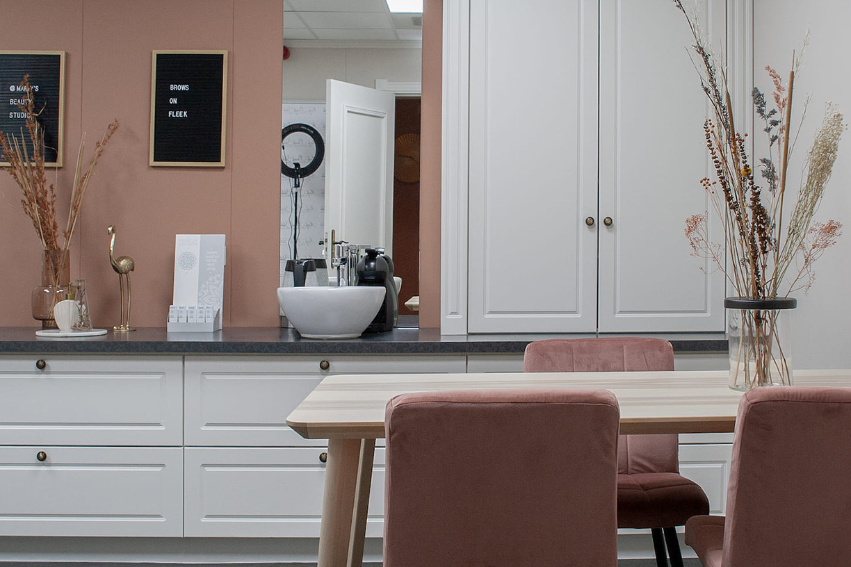 De lounge van de beautysalon met roze fauteuils
